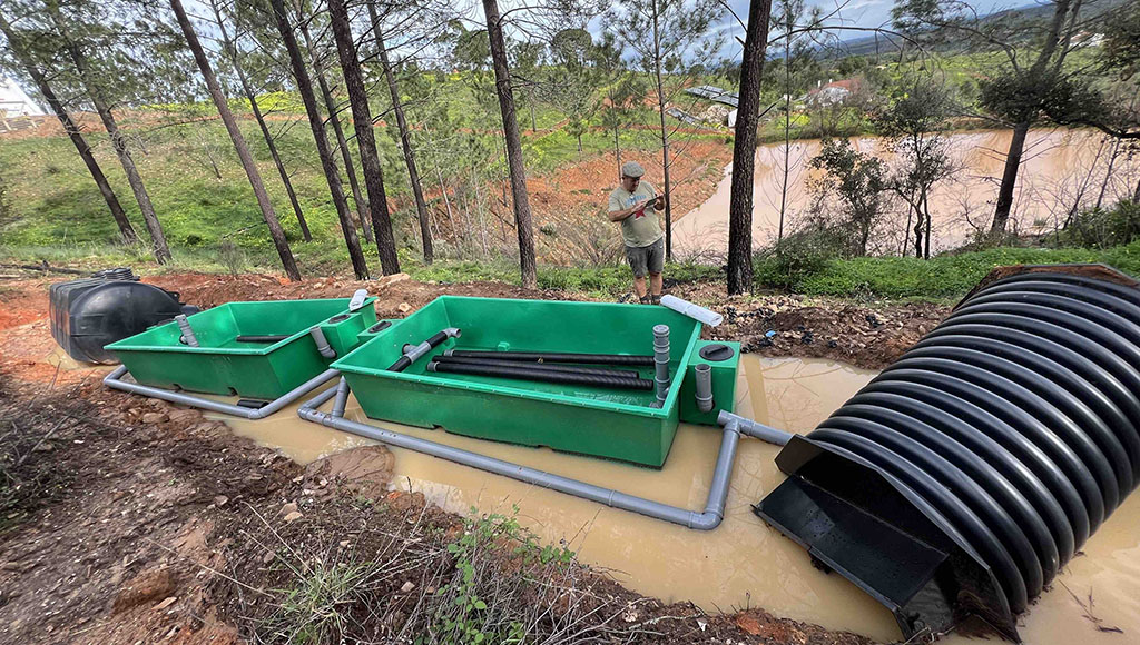 Alastair inspecting the ruined fossa reed-bed and tank water treatment system after the flood and landslide