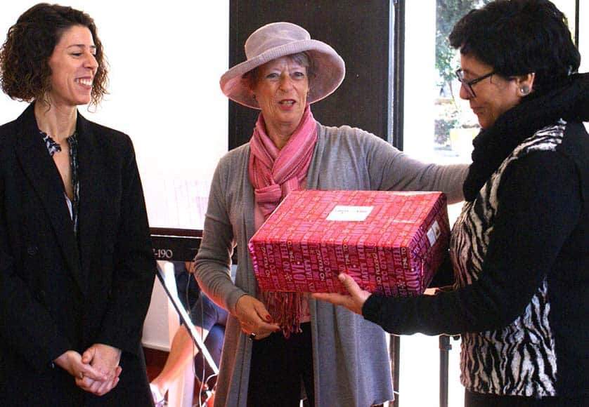 Jane Caulfield-Kerney (centre) presenting one of the 42 Christmas gifts to Dra Sandra Vale, President ASCA, and Vitalina Azevedo, Director ASCA
