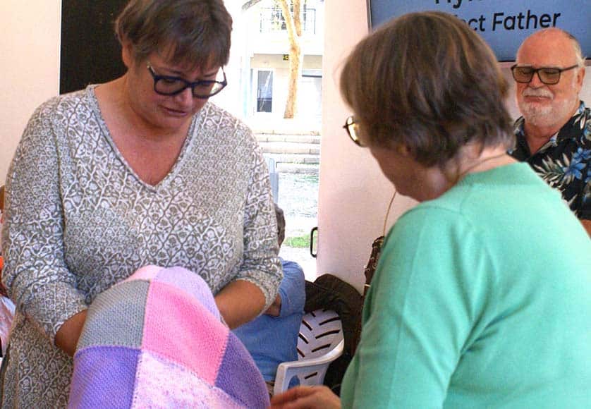 Sandy MacDougall (right) presenting one of a bundle of hand-made blankets to Kaye Jones from the Portimão Soup Kitchen