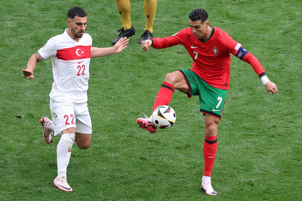 Cristiano Ronaldo in action against Kaan Ayhan during the UEFA Euro 2024 group F soccer match between Turkey and Portugal, in Dortmund, Germany, on June 22, 2024. Photo: EPA/CHRISTOPHER NEUNDORF|A file photo dated March 1970 shows Portuguese legend Eusébio da Silva Ferreira posing in a Benfica Lisbon jersey. Portugal declared three days of morning following his death on January 5, 2014, aged 71. Photo: EPA/MANUEL MOURA