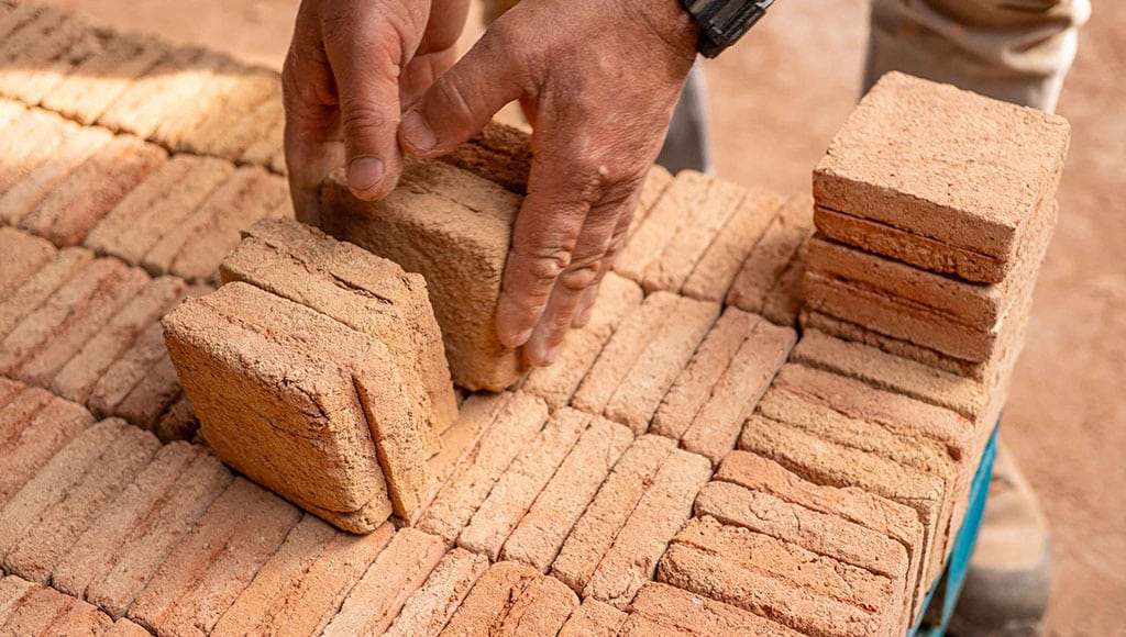 10cmX10cm tiles arranged on a pallette|Alexandre Caetano and Ildefonso Viegas move dried tiles to the oven|Aurélio do Carmo and Vasco Parreira unload finished tiles from the oven and onto a pallette|Break time|Elisabete Rocha stands in front of oven|Entry to the tile factory|Ildefonso Viegas chooses a tile frame for the next batch|Ildefonso Viegas makes tile|Joaquim Sola and Valter Contreiras arrange tiles in the oven for firing|Ricardo Gonçalves flattening wet tiles|Ricardo Gonçalves flattening wet tiles|Vasco Parreira stripes tile
