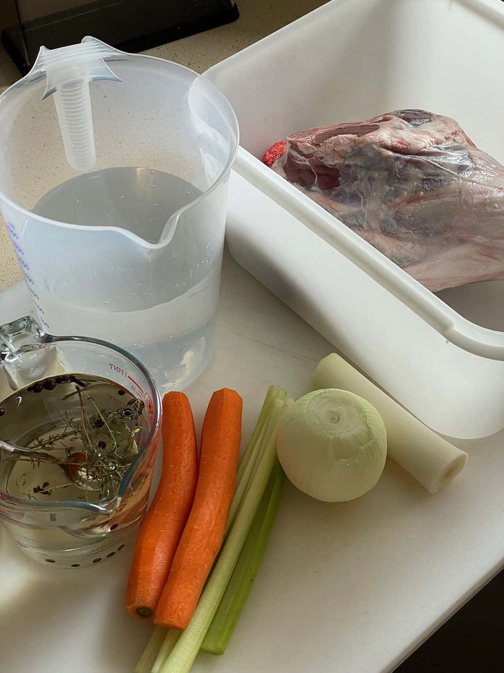 A leg of lamb is waiting for its bath|A pork loin in a wet brine
