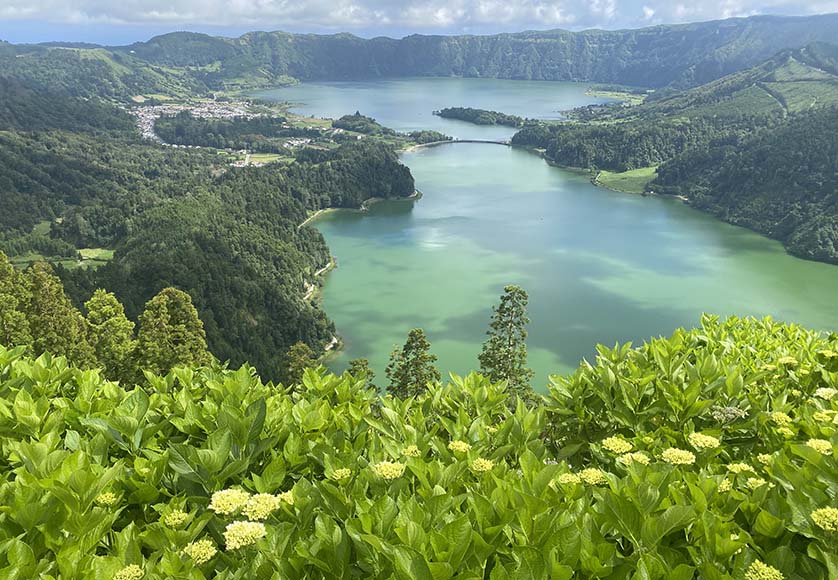 The twin crater lakes of Sete Cidades (blue lake on top, green lake below), with the town of Sete Cidades in the middle left|Praça Gonçalo Velho Cabral is Ponta Delgada’s main square, with its three-arch gateway, with the São Sebastião cathedral behind.|The 17th century Paços do Concelho (Town Hall) of Ponta Delgada, fronted by a statue of the Archangel Michael|The cloisters of the Convento de São Francisco|Several of the Caldeiras at Furnas, each containing the food of a different restaurant, as marked by the plaques|The floral decorations on the roads of Povoação on Corpus Christi day|The Igreja Matriz de São Jorge in Nordeste, with a statue of António Alves de Oliveira (1847-1936), an important politician, in front|The Vila Franca do Campo town hall, with a statue of Gonçalo Vaz Botelho, a companion of Gonçalo Velho Cabral, in front|A private chapel in the grounds of the Pestana Bahia Praia hotel|A view of the northeastern coast of São Miguel|The Ermida de Nossa Senhora da Paz, on a hill overlooking Vila Franca do Campo|The volcanic crater island called Islet, just off the Vila Franca do Campo coast