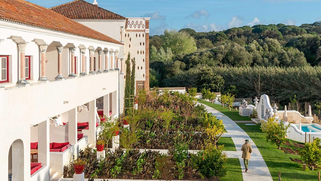Individual gardens outside Vermelho guestrooms|Eric Roth photographs Vermelho, photo by Lucille Wymer|Friendly staff at the reception desk. Wall art by Klove Studio, New Delhi, India|Giuseppe Ducrot ceramic sculpure at Vermelho|Lounge, Vermelho|Vermelho balcony|Vermelho bar by Villarreal Workshop, Seville|Vermelho entry|Vermelho facade with Giuseppe Ducrot ceramic window borders|Vermelho guestroom with four post bed|Vermelho guestroom with handpainted details|Vermelho guestroom with Spanish brass doors|Vermelho landing with abstract mollusk chandelier|Vermelho terrace with bold ceramics by Giuseppe Ducrot