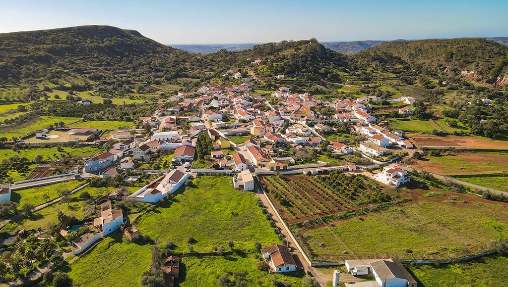 My village in the hills of the Algarve|Camaraderie in Évora square|Celebrators of traditional marches in Portimão|Classic Algarve chimney, showing Moorish design influences today|Cloaked students at University of Coimbra were popularized by Harry Potter|Exquisite tilework of São Bento Railway Station, Porto|Iconic limestone formations, Praia da Rocha, Portimão|My neighbor Manuel de Simone, with his favorite Carob Tree|Remodelado trams, Lisbon|Statue of Henry the Navigator, Porto|Storks thrive harmoniously throughout Portugal_|The magnificent Convento de Christo, Tomar|Tomar convent courtyard where the Knights Templar once walked|Traditional Loulé door|Vintage Algarve road signs, Barranco do Velho|Vintage Schweppes tile mural in Boliqueime