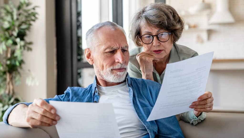 Senior old elderly spouses grandparents reading documents, having issue problem debt with money loss, doing paperwork together at home. Mortgage, loan and commerce procedures|Portugal Pathways