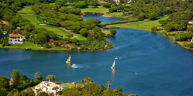 Aerial view of the Quinta do Lago resort highlighting its low housing density eco footprint|Partial view of Quinta do Lago’s high-performance sports and fitness hub, The Campus|The inside of Dano's Sports Bar & Restaurant, part of Quinta do Lago eco planning|Quinta do Lago's South Course - 16th hole, a eco-friendly golf resort