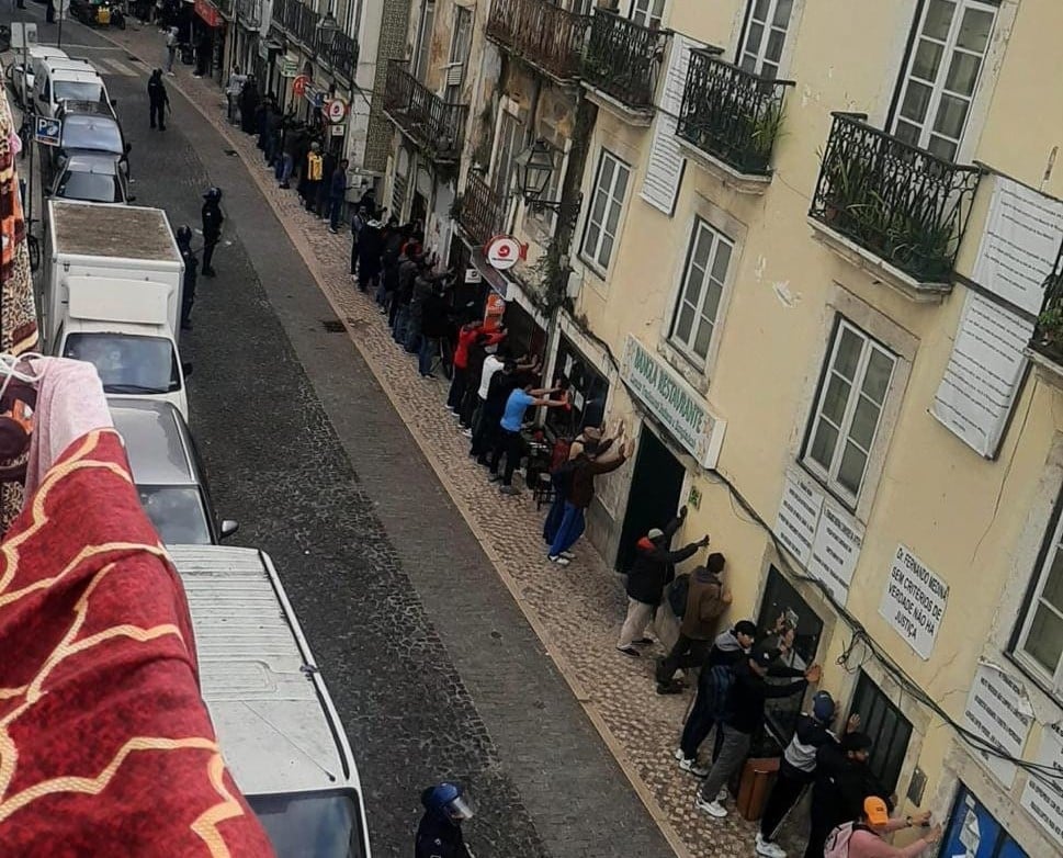 Photo widely shared on social media, showing dozens of immigrants lined up against walls as part of Thursday's police operation in Martim Moniz.