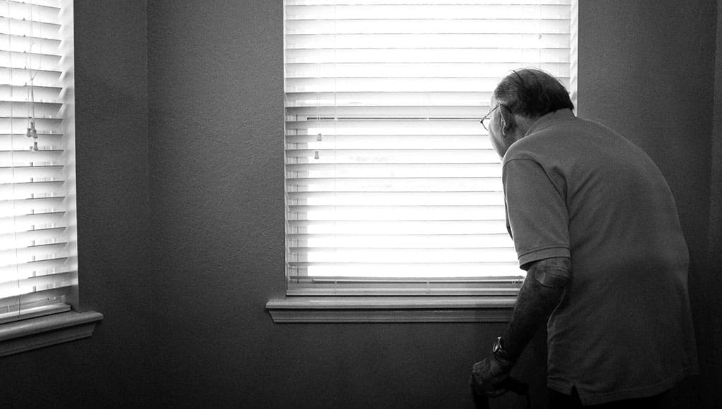 elderly man looking out of window