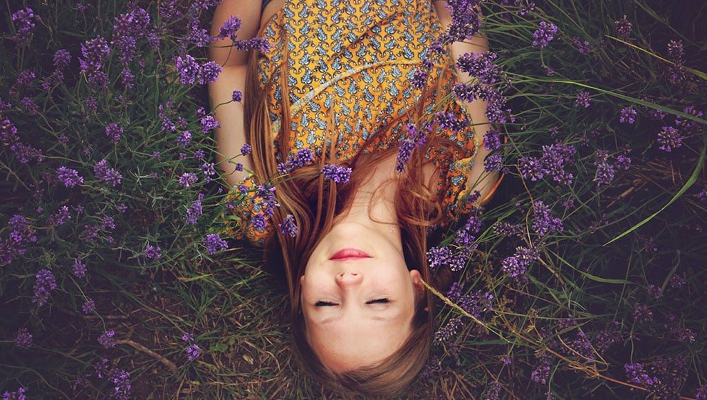 woman lying on bed of flowers