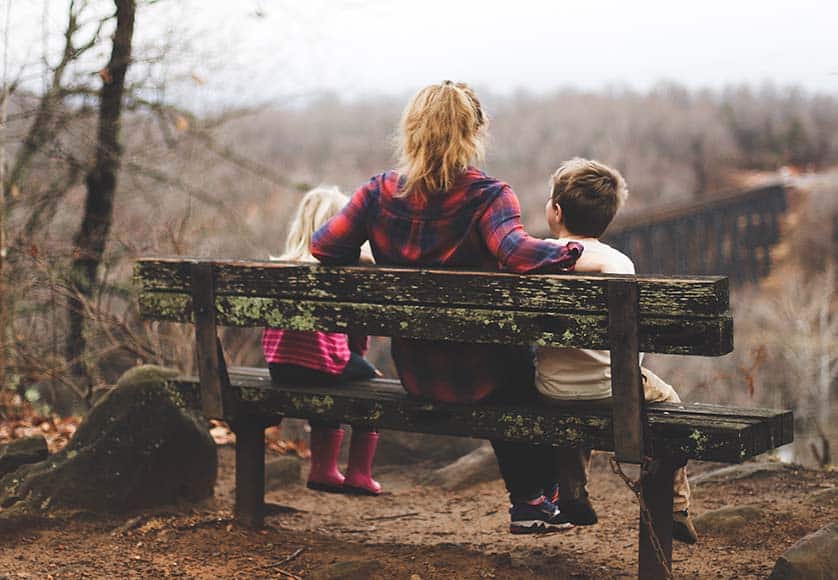 woman sitting with children on bench