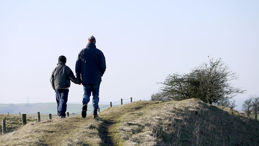father and sun walking holding hands