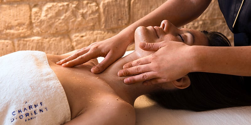 Partial image of a woman undergoing a facial massage at Bricia du Mar|Cups of special wellness products offered at Bricia du Mar|A man an a woman stretching outside at Bricia du Mar|Photo of the inside of Bricia Health & Wellness Gym