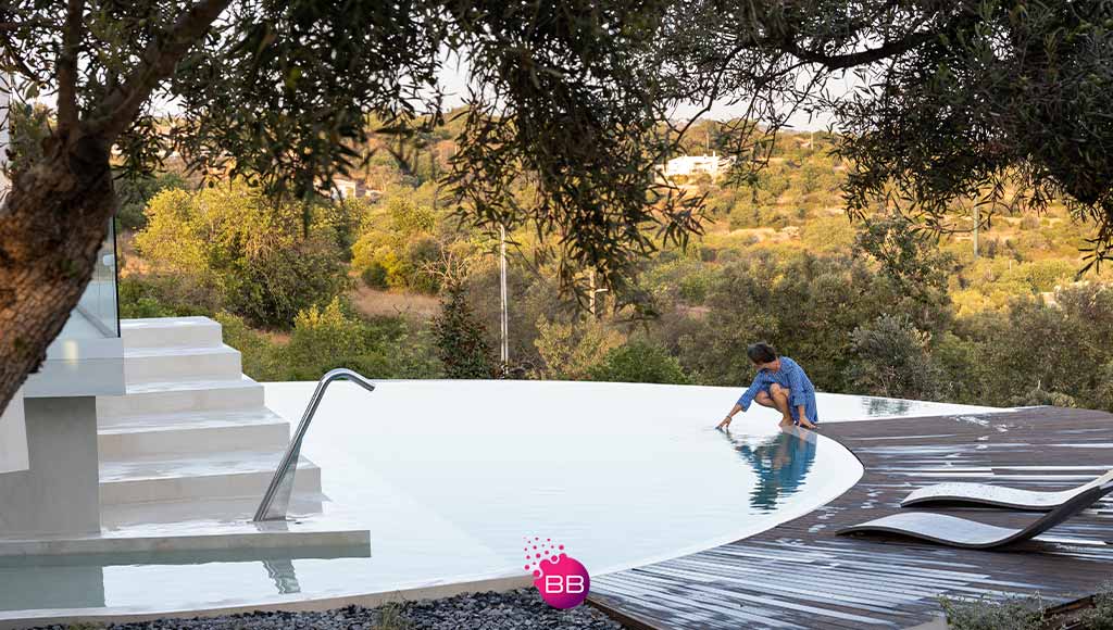 Anabela Macieira, founder of Core Architects checking a swimming pool on one of the properties she has designed|View of part of a living room created with Core & More interior design service|View of part of a hallway created with Core & More interior design service