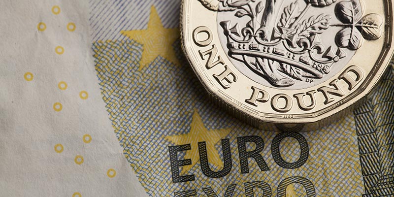 Partial image of a Euro bill and a pound coin to illustrate the currency market||Photo of the outside of Currencies Direct office in the Algarve