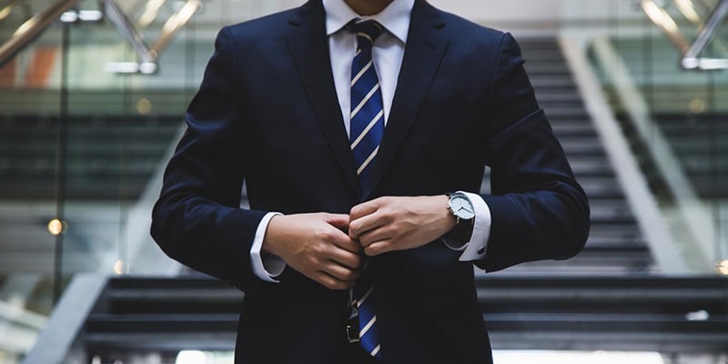 Image of a businessman torso buttoning up his jacket to symbolise investors
