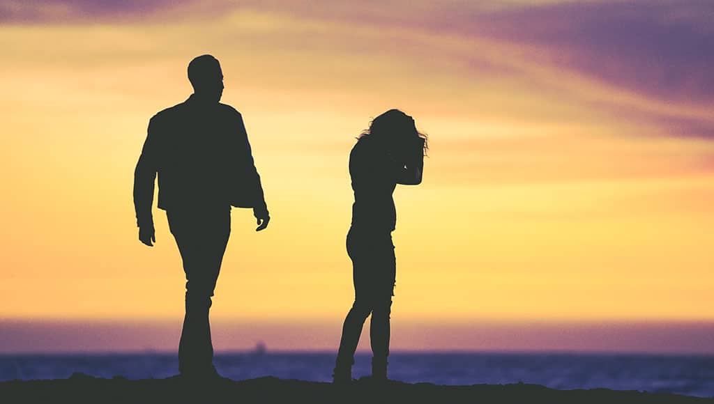 Two people walking during sunset