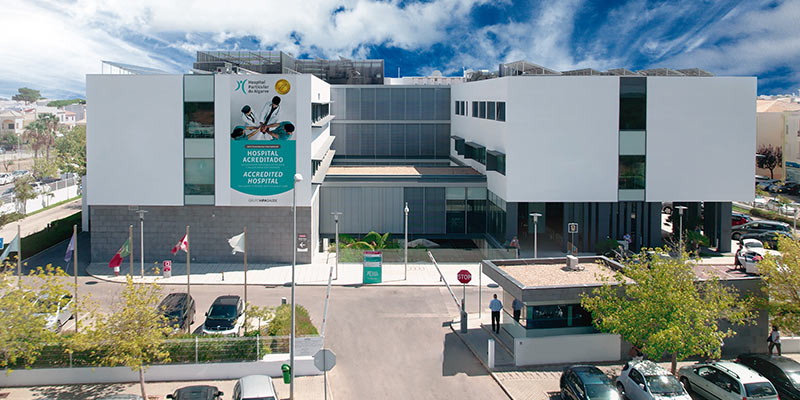 Photo of the facade of HPA Health Group's hospital in Gambelas, Faro|An operating room with a surgical team in one of HPA's hospitals in the Algarve, Alentejo and Madeira.
