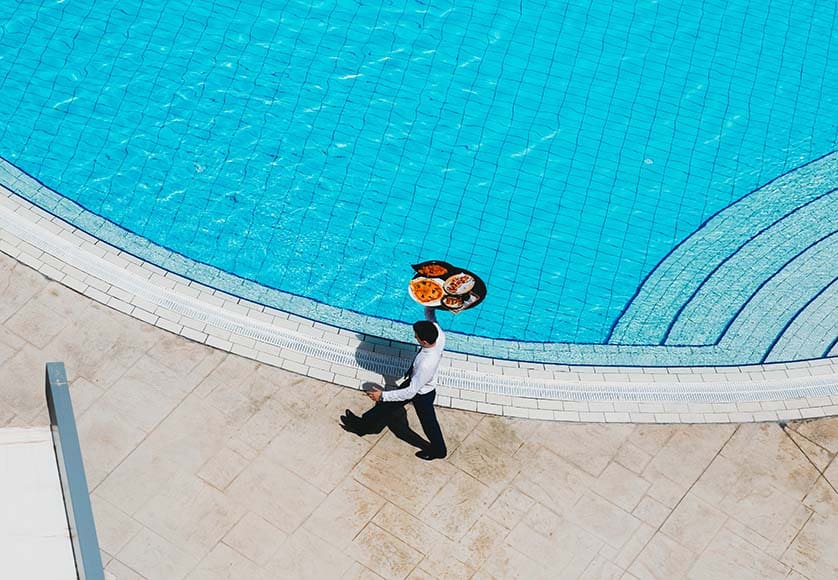 waiter by swimming pool