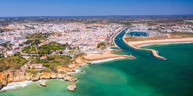 Aerial view of part of the Algarve coastline, one of the best regions to own a property in Portugal|Partial view of the Algarve coast, one of the best regions to buy a property in Portugal|Partial view of a beach in the Algarve region