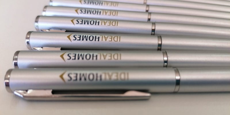 Several Ideal Homes International pens aligned on a table.