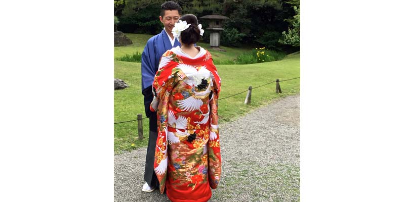 Japanese couple in Hama-rikyu gardens posing for their wedding photographs