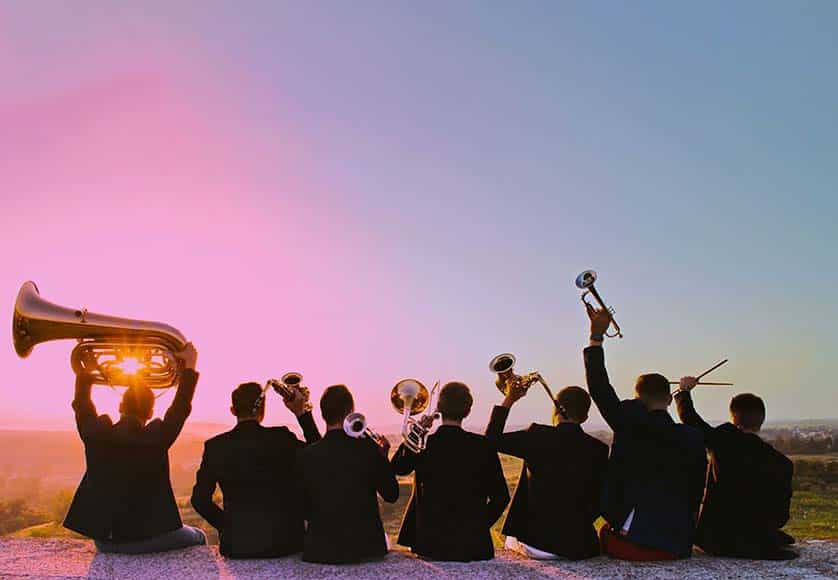 Happy young people with musical instruments in dusk