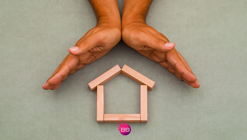 A pair ove hands over the symbol of a house in wood to symbolise home insurance|Home insurance – why you must have it and keep it updated|Home insurance – why you must have it and keep it updated