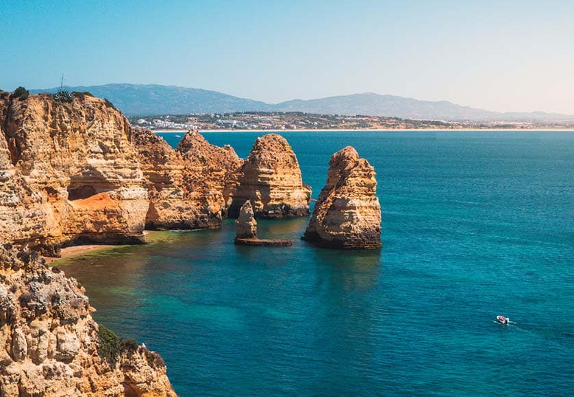 Mesmerizing shot of Ponta da Piedade, a scenic spot in Portugal|algarve-rentals-the-vines-accommodation-quinta-dos-vales-estate|eating-algarve-sardines-food-quinta-dos-vales-activities|Female in Ponta da Piedade, a scenic spot in Portugal|wine-tastings-quinta-dos-vales-algarve-activities-food
