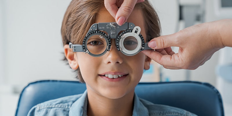 Young boy doing an eye check-up|children in classroom