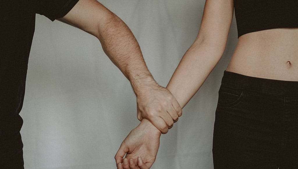 accused of rape man hand holding womans wrist