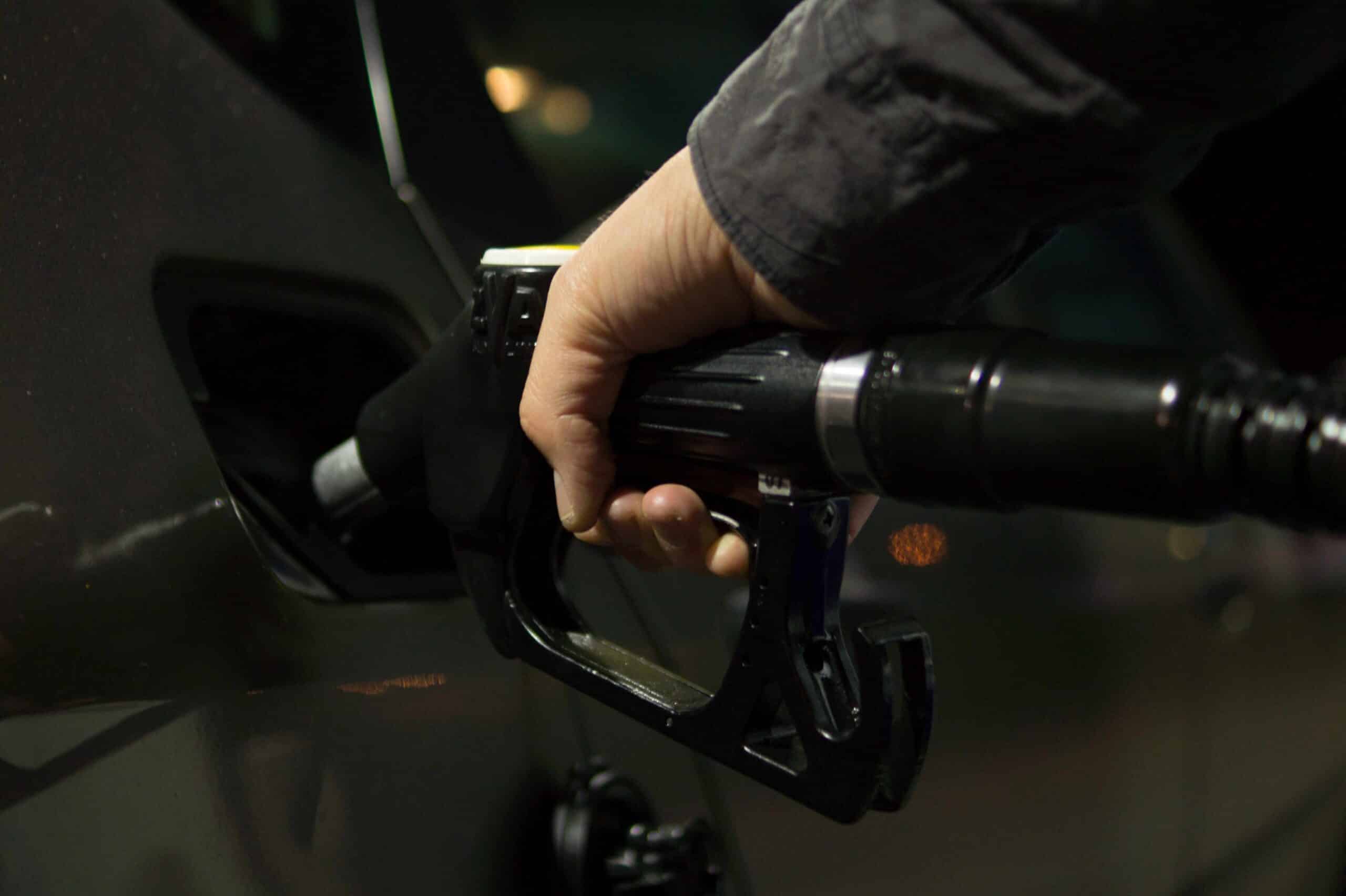 person putting fuel in car