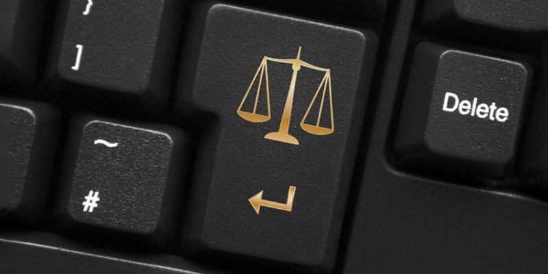 A keyboard with the scales of justice in the Enter key symbolising the legal work Projuris Advocacia offers.