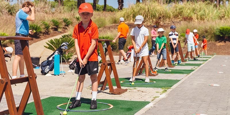 Kids playing golf at Quinta do Lago's Sports Academies|Boy running at Quinta do Lago's Sports Academies|Children doing warm-up exercises at Quinta do Lago's Sports Academies|Children diving into a pool|