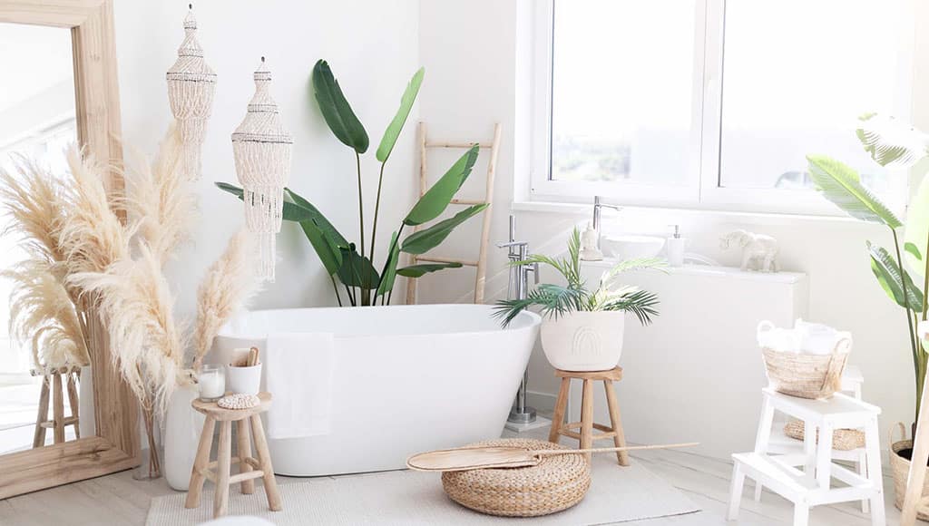 Stylish Interior Of Light Bathing Room With Rustic Decorations In Boho Style, Cozy Spacious Bathroom With Natural Green Plants Near Window And Big White Bath Tube Inside, Free Space