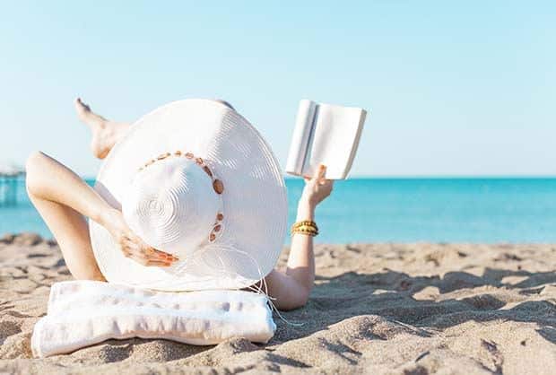 shutterstock_437089297_portrait-of-a-young-brunette-relaxing-on-the-beach-reading-a-book.jpg