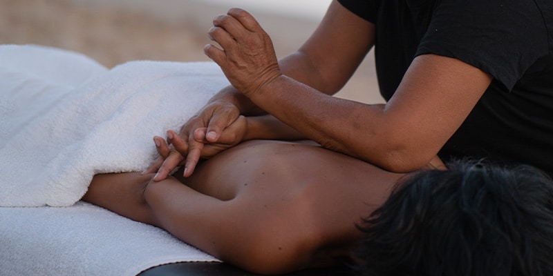 Woman outside receiving deep tissue massages from one of Sokura's therapists|woman receiving massages at her office
