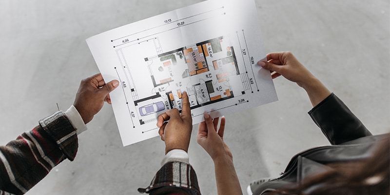 The hands of 2 people holding a schematic for an off-plan property|Togofor-homes logo
