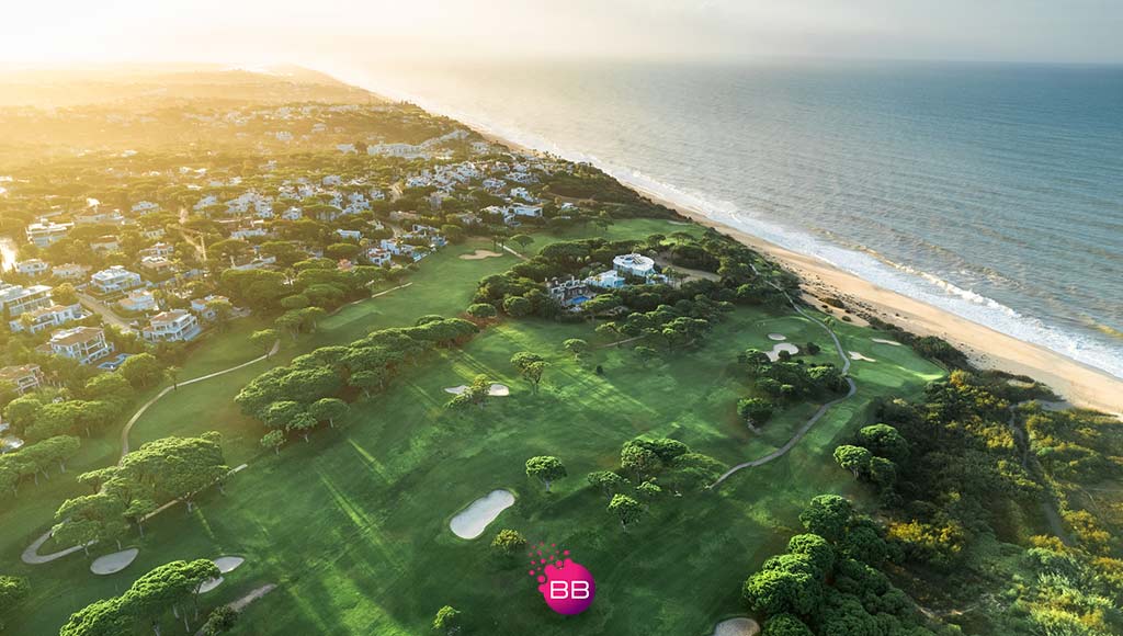Aerial view of part of the Vale do Lobo resort|Aerial view of part of the Vale do Lobo resort|Photo of a couple on the balcony at one of Vale do Lobo's properties|View of part of one of Vale do Lobo's golf courses