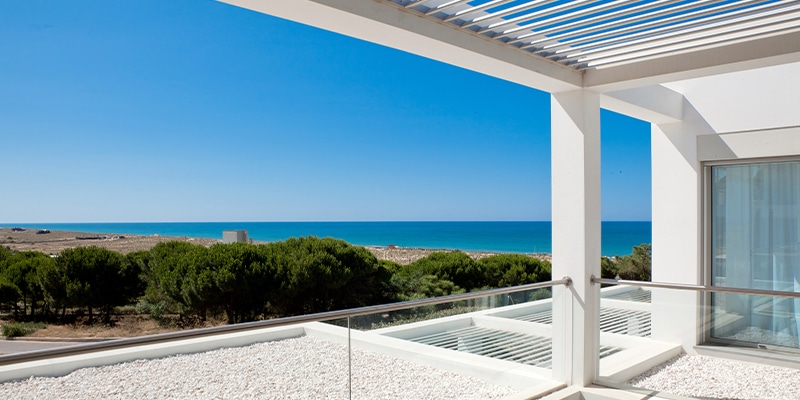 Sea view from one of the villas that have contributed for the increase in property sales at Vale do Lobo|||Aerial view of one of the pools at the Vale do Lobo resort|Photo of family by the pool in one of the Vale do Lobo villas