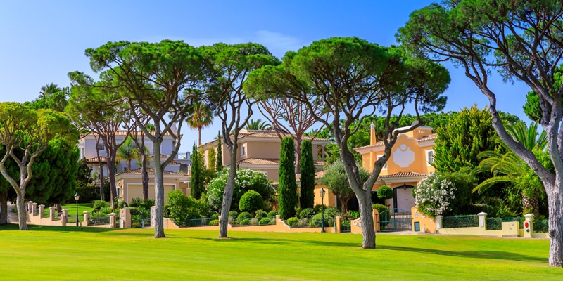 Private villas in Vale do lobo where the rise of real estate investment was felt|People working out outside as part of a quest for wellness havens trend that helps explain real estate investment in Portugal|Aerial view of part of one of Vale do Lobo's golf courses, also feeling the rise in real estate investment in the Algarve|Two girls entering a pool on a property to simbolize the rise in real estate investment in Portugal