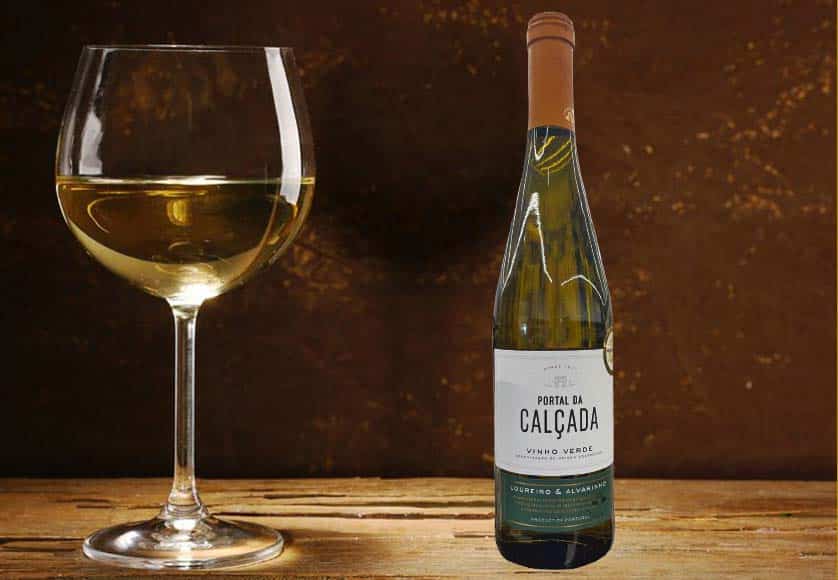 Goblet of white wine on wooden table on wooden wall background