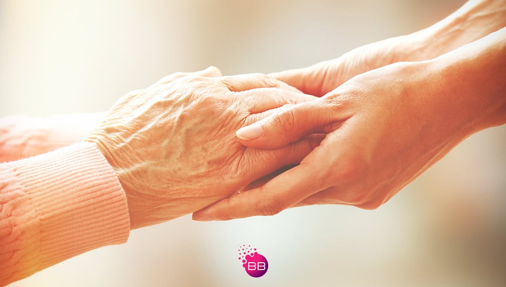A senior and another person holding hands to symbolise the home care services that Joy4Caring offers in the Algarve
