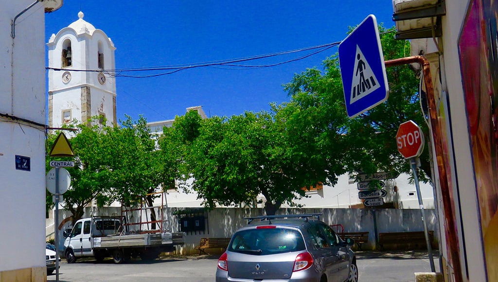 The Tee intersection at the entrance to Santa Bárbara de Nexe. Turn left, two-way; turn right one-way. Church bell tower in the background