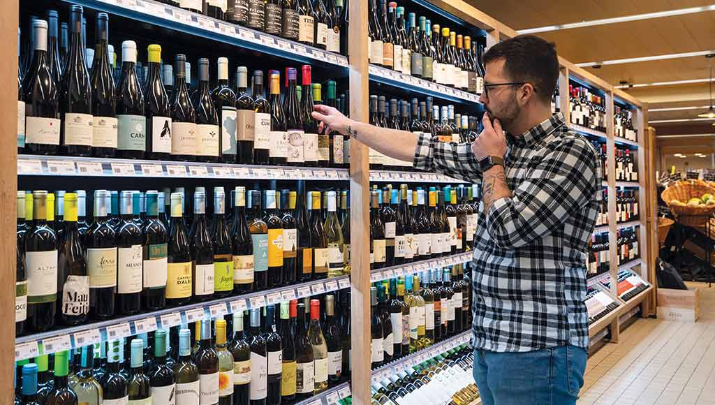 A customer choosing wines at Baptista Supermarket