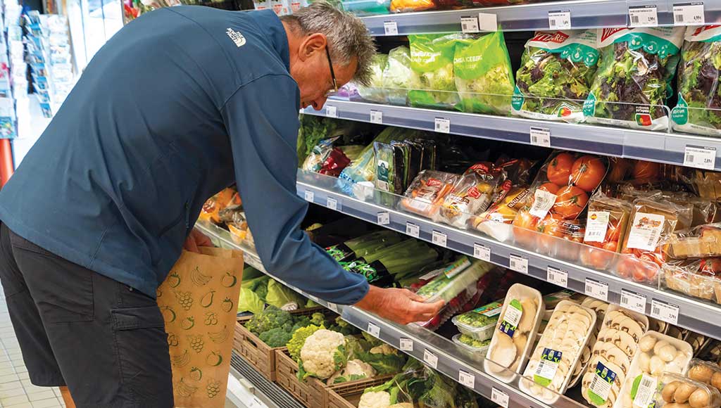 A man choosing vegetables at the Baptista Supermarket
