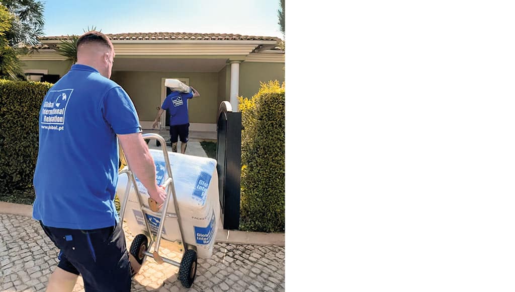 Two team member of Global International Relocation moving boxes into a client's new home as part of their international move