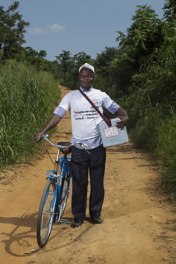 A healthcare worker heads out on his bicycle during National Immunization Day in Cote d'Ivoire - Photo: Rotary International