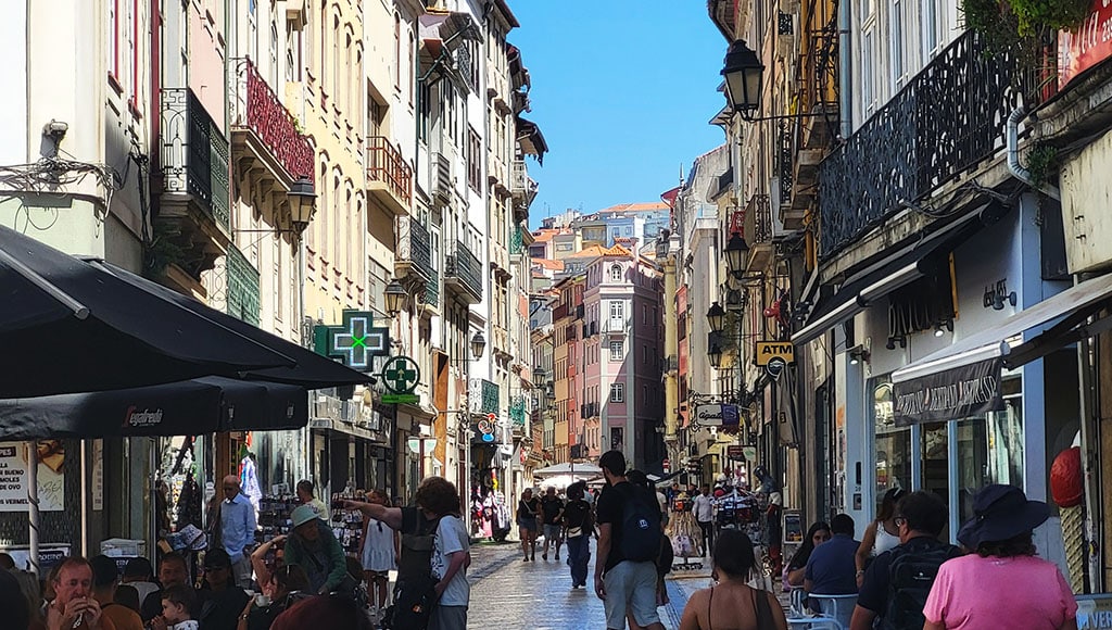 Old town on the rise - Coimbra’s main street climbs toward the upper city, alive with shops, chatter, and layered rooftops.