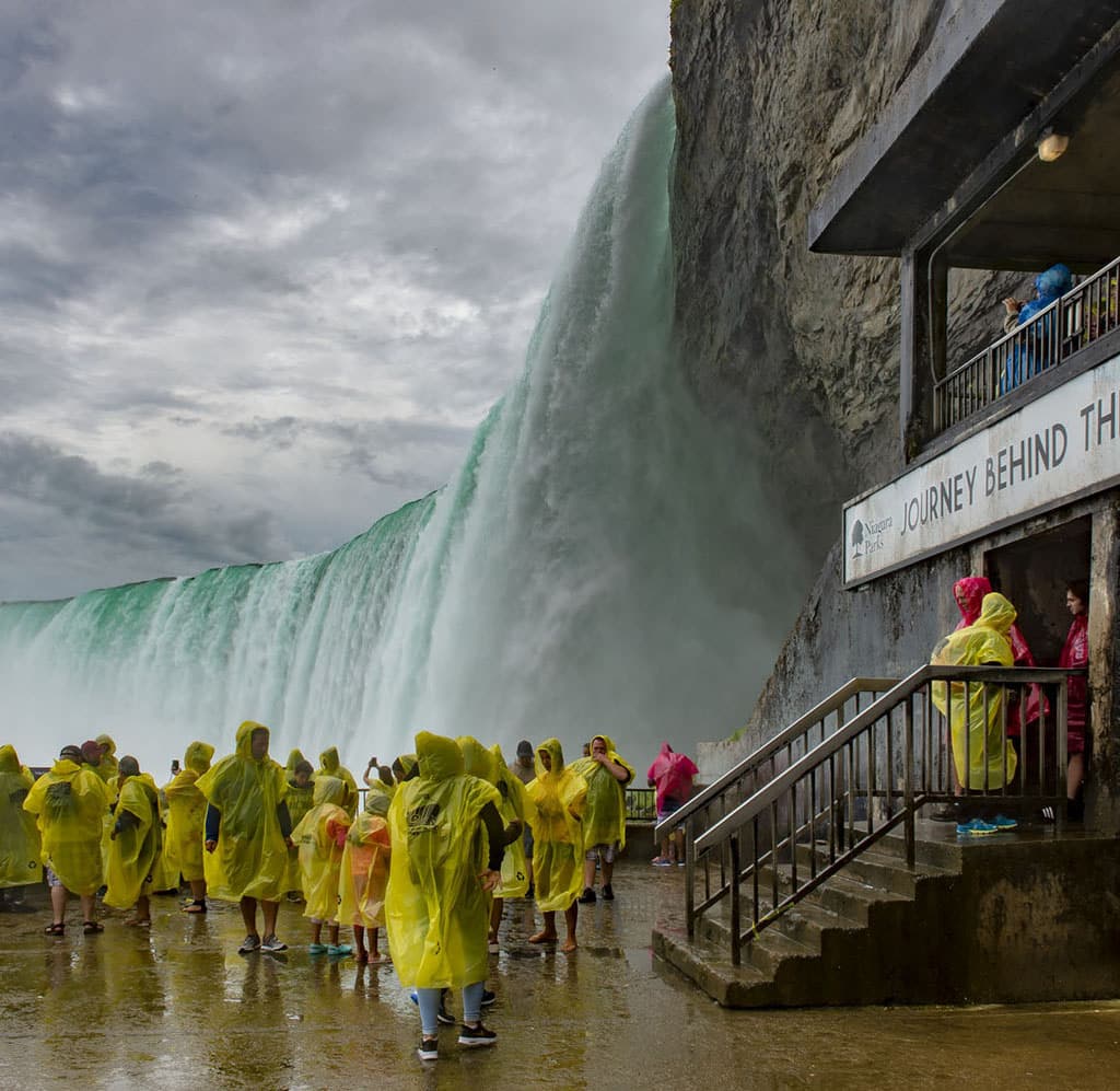 People take part in the journey behind the falls experience at Niagara Falls (Canada)